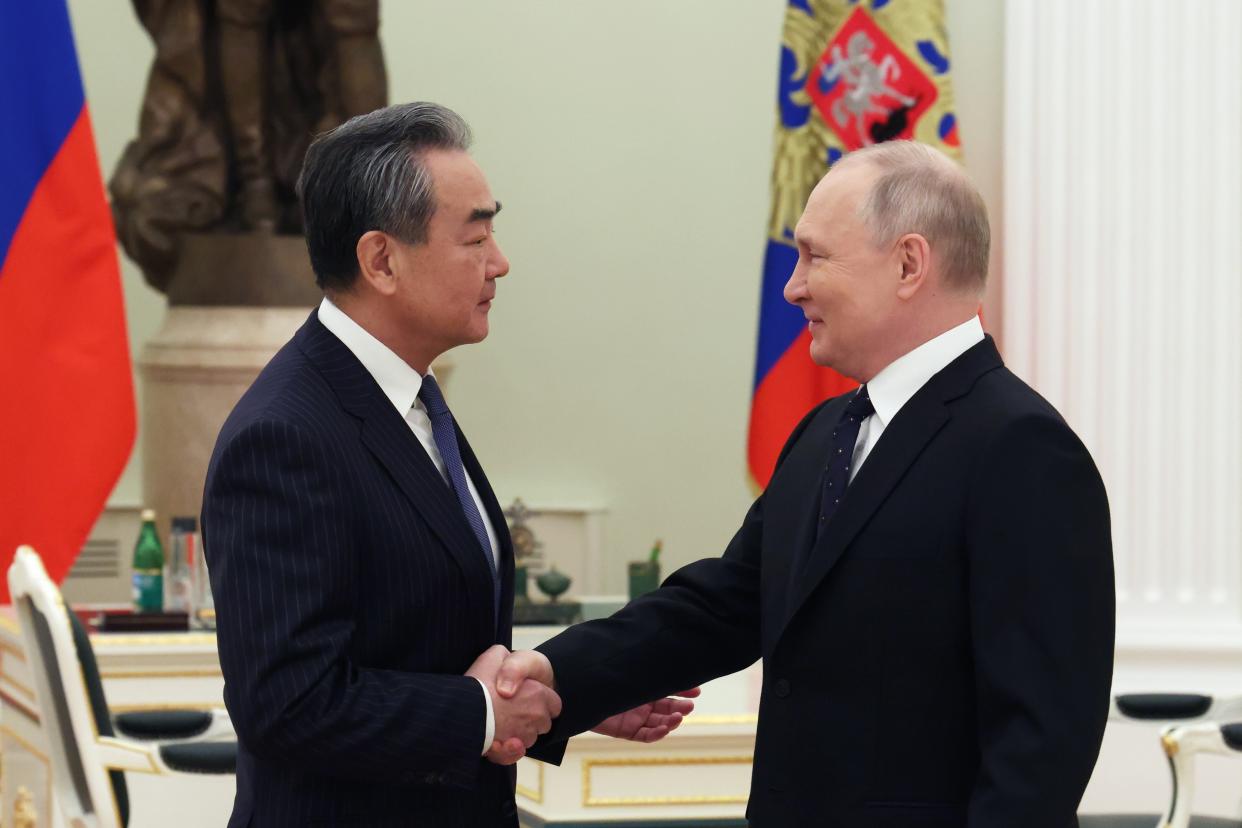 Russian President Vladimir Putin shakes hands with Chinese Communist Party's foreign policy chief Wang Yi during their meeting at the Kremlin in Moscow, Russia, Wednesday, Feb. 22, 2023. (Anton Novoderezhkin, Sputnik, Kremlin Pool Photo via AP)