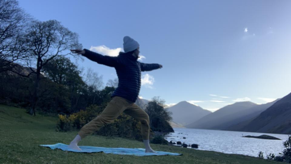 Woman doing yoga next to a lake