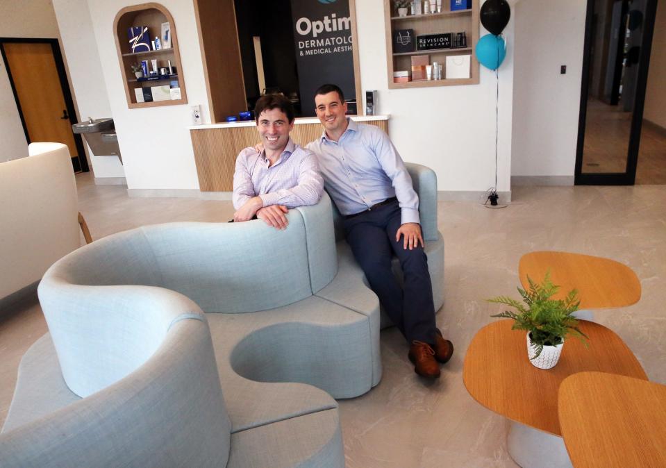 CEO Max Puyanic, left, and Chief Growth Officer Ben Collins show off the entry waiting room at the new Optima Dermatology facility in Stratham.
