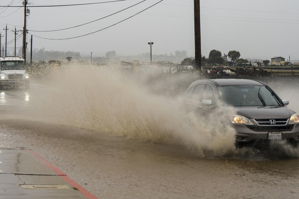 Cars drive through a flooded section of Harrison Road in Salinas, Calif., Saturday, Dec. 31, 2022. (AP Photo/Nic Coury)