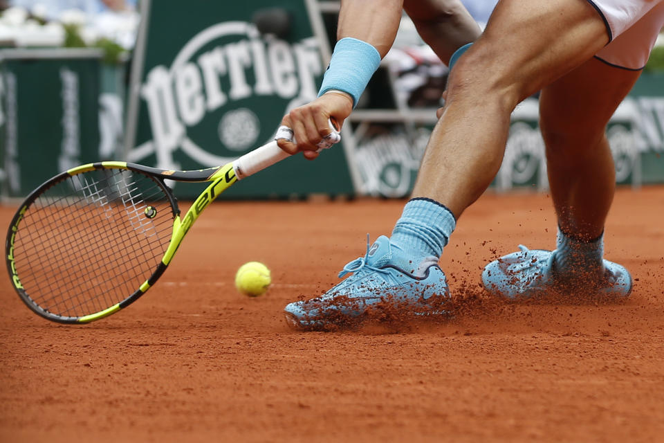 FILE - Spain's Rafael Nadal runs and slides to return a shot in his second round match of the French Open tennis tournament against Argentina's Facundo Bagnis at the Roland Garros stadium in Paris, France, Thursday, May 26, 2016. The French Open is the only Grand Slam tournament held on clay — which actually isn’t truly clay, but the dust from red brick on top of a layer of crushed white limestone. (AP Photo/Alastair Grant, File)