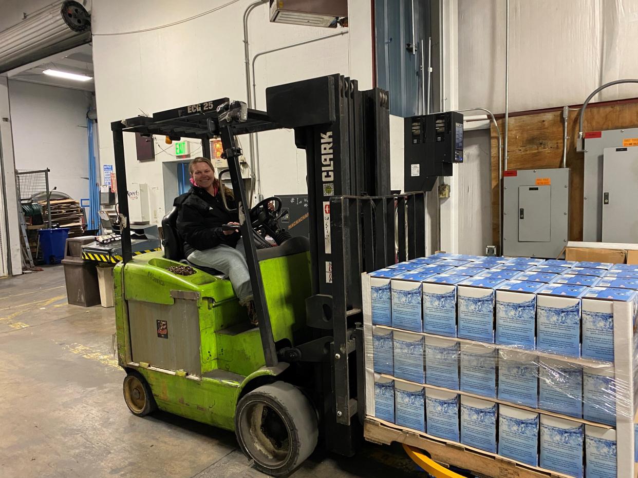 Desiree Cowan moves a palate of boxed and bagged Castle Rock water in preparation for it to be sent to the people of East Palestine, Ohio.