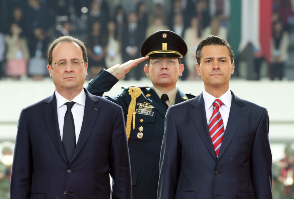 French President Francois Hollande, left, and Mexico's President Enrique Pena Nieto, right, attend a welcoming ceremony at the Campo de Marte military field in Mexico City, Thursday, April 10, 2014. Hollande is in Mexico for a two-day official visit. (AP Photo/Alain Jocard, Pool)