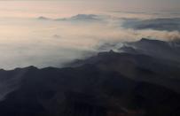 Smoke from bushfires blanket mountain ranges as seen during a commercial flight over northern New South Wales