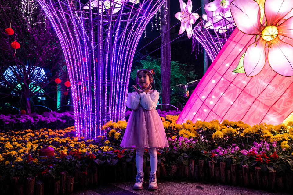 A child stands in front of flowers in Guangzhou Cultural Park during the Lantern Festival on Feb. 5, 2023.
