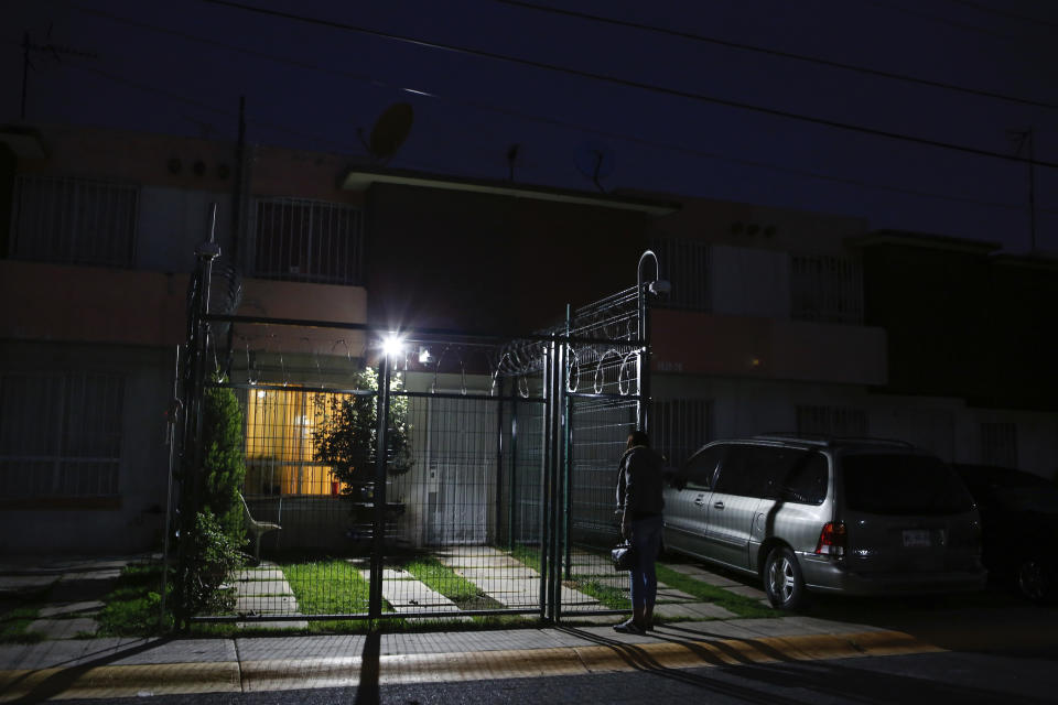 In this Aug. 28, 2019 photo, trans rights activist Kenya Cuevas shuts the gate to the security fence that surrounds her home, in Chalco, Mexico. Months after Cuevas' friend was slain in front of her, a funeral wreath with Cuevas' name on it arrived at her doorstep. The implication was clear: Keep making noise about murdered transgender women and you'll be next. (AP Photo/Ginnette Riquelme)