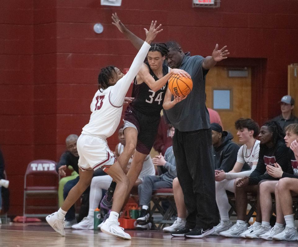 Joshuah Cooper (34) passes the ball before going out of bounds during the Navarre vs Tate boys basketball game at Tate High School on Friday, Jan. 12, 2024.