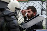 Riot police officers detain a protestor near the Agriculture ministry in Athens on February 12, 2016