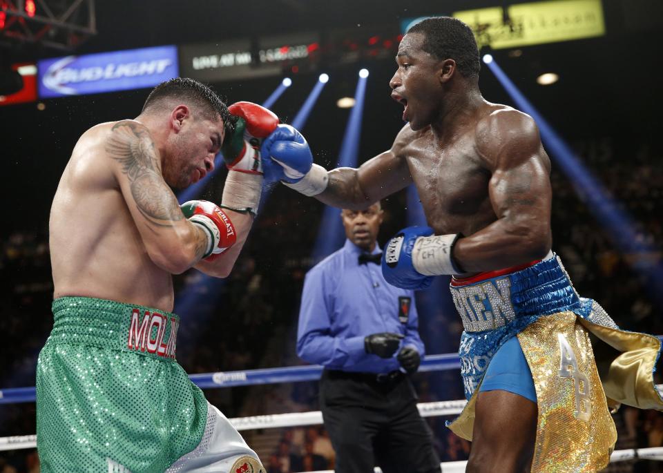 Adrien Broner, right, from Cincinnati, Ohio, trades blows with Carlos Molina, from Norwalk, Calif., in their WBA super lightweight title boxing fight Saturday, May 3, 2014, in Las Vegas. (AP Photo/Eric Jamison)