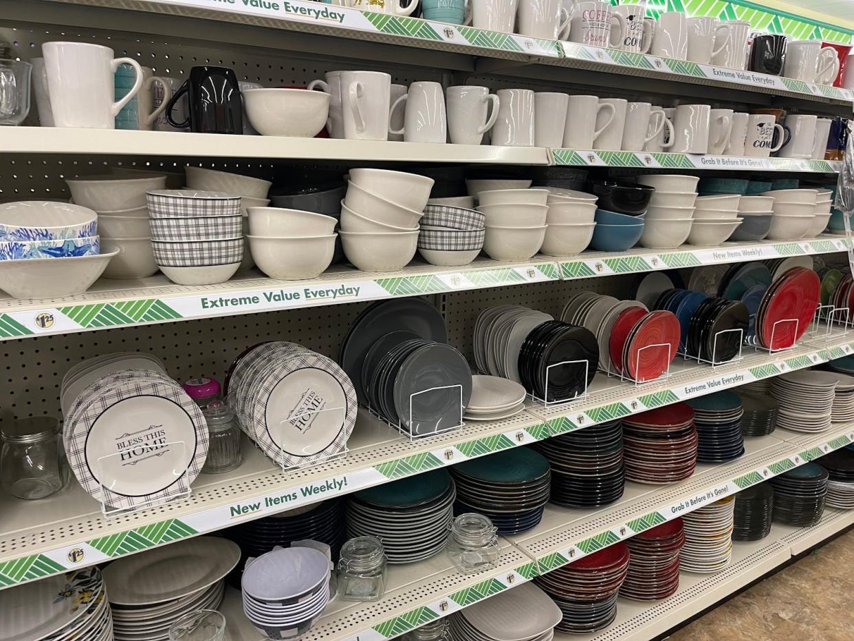 Mugs, bowls, and plates on display at a store.