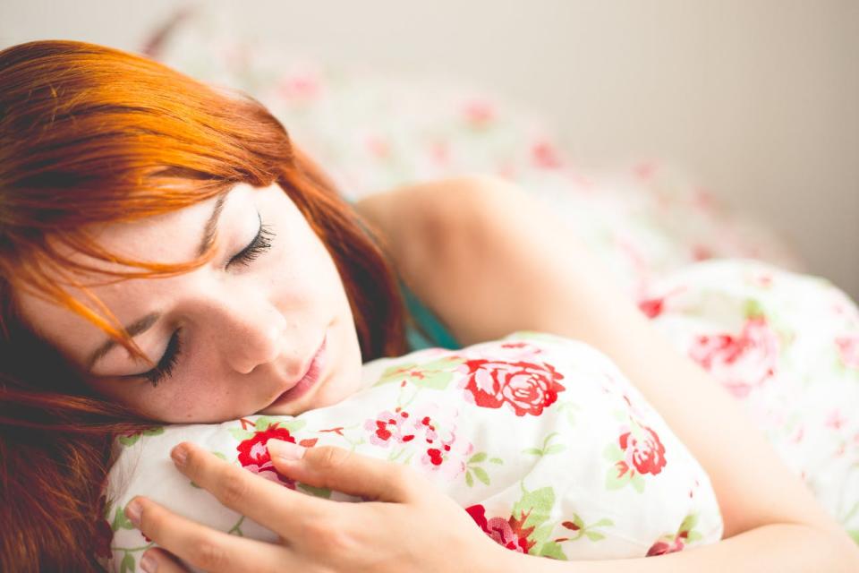 A woman curls up with her blankets.