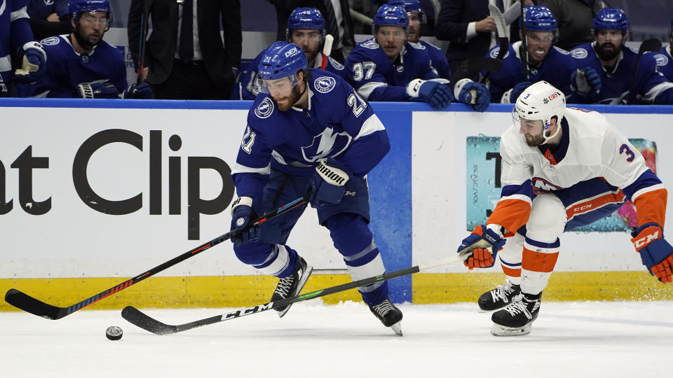 Tampa Bay Lightning center Brayden Point (21) gets around New York Islanders defenseman Adam Pelech (3) during the second period in Game 1 of an NHL hockey Stanley Cup semifinal playoff series Sunday, June 13, 2021, in Tampa, Fla. (AP Photo/Chris O'Meara)