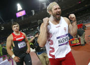 Germany's David Storl (L) watches as Poland's Tomasz Majewski celebrates after winning the men's shot put final during the London 2012 Olympic Games at the Olympic Stadium August 3, 2012. Majewski placed first ahead of Storl who placed second and Reese Hoffa of the U.S who finished third. REUTERS/Kai Pfaffenbach (BRITAIN - Tags: OLYMPICS SPORT ATHLETICS) 