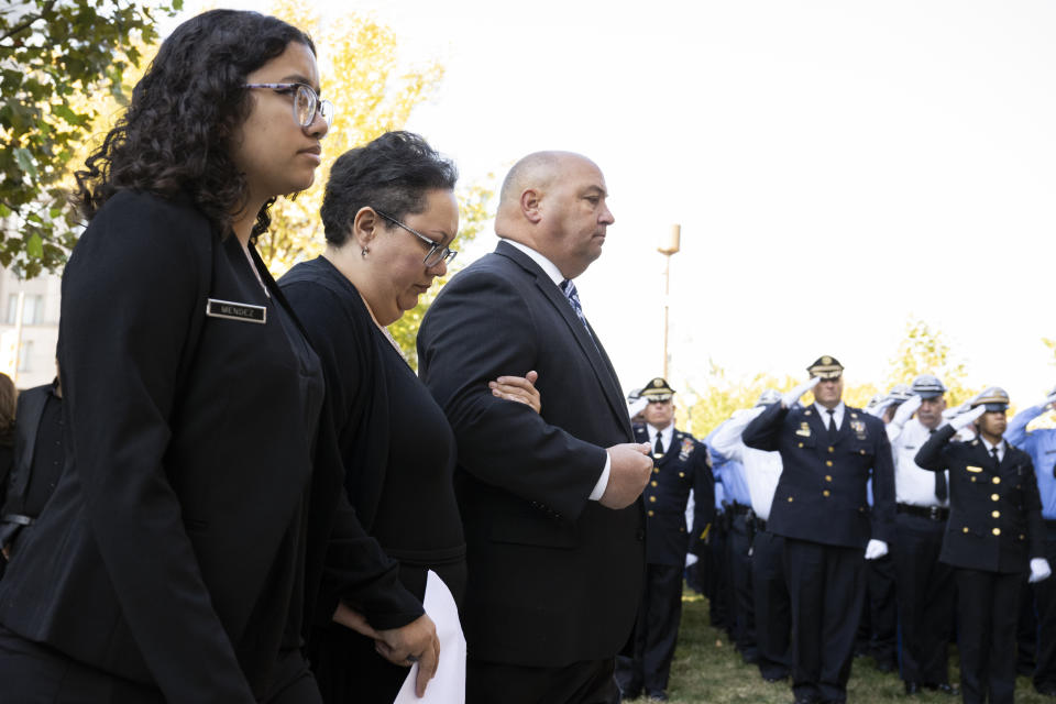 Alex Mendez, center, arrives for the viewing of her husband, officer Richard Mendez, alongside their daughter Mia Mendez at the Cathedral Basilica of Saints Peter and Paul in Philadelphia, Tuesday, Oct. 24, 2023. Mendez was shot and killed, and a second officer was wounded when they confronted people breaking into a car at Philadelphia International Airport, Oct. 12, police said. (AP Photo/Joe Lamberti)