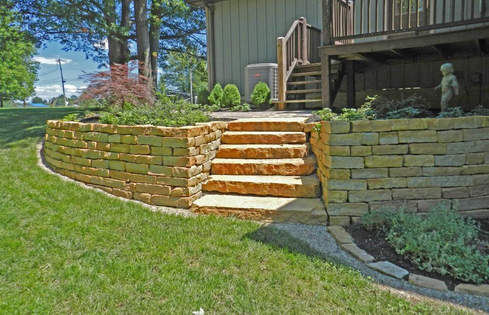 Natural stone gives retaining walls more character, but it takes some skill and experience to build them strong.