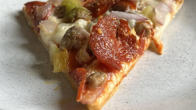 A slice of Tombstone 'The Primo' Tavern Style Pizza