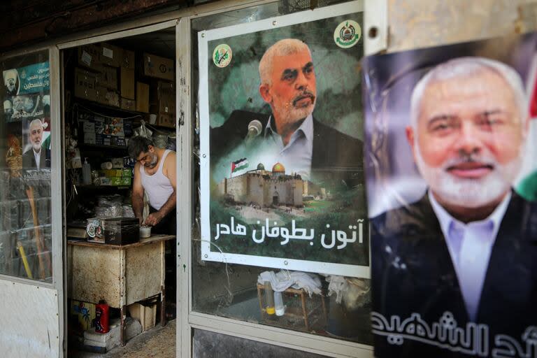 Un palestino trabaja en su tienda en el campo de Burj al-Barjneh en Beirut adornado con carteles del asesinado líder de Hamas, Ismail Haniyeh, y de Yanya Sinwar (izq.), quien fue nombrado nuevo líder para suceder a Ismail Haniyeh, asesinado en Teherán
