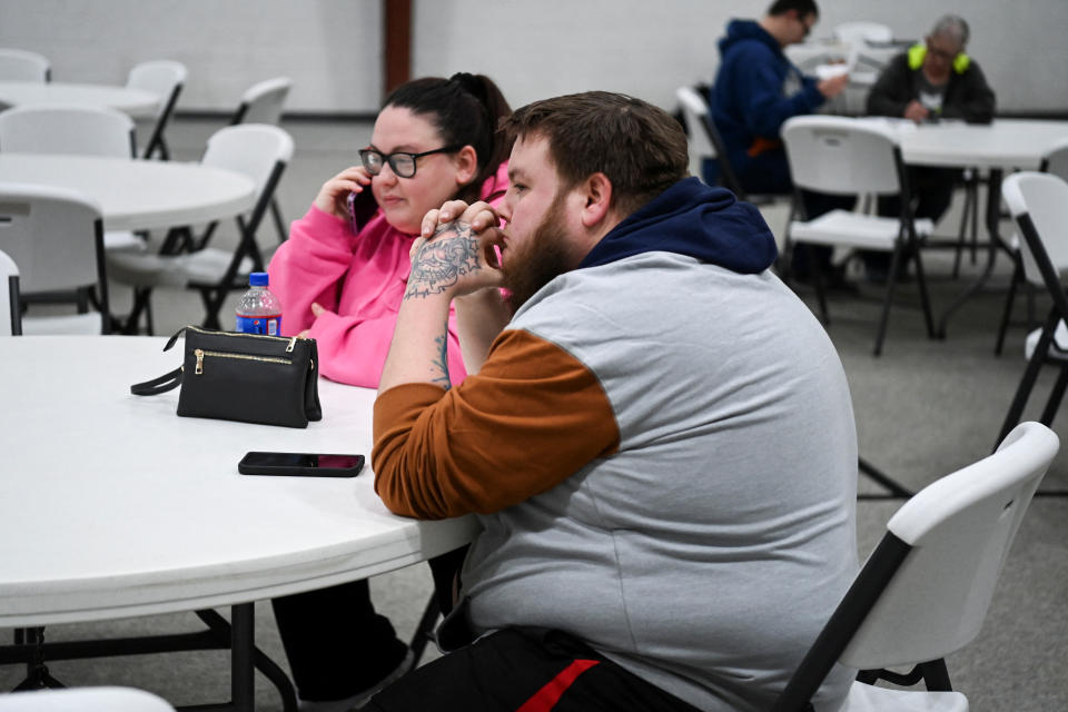 Brittany Vargo and Marcus Turner sit at an assistance center, following a train derailment that forced people to evacuate from their homes, in New Waterford, Ohio, U.S., February 6, 2023.  REUTERS/Alan Freed