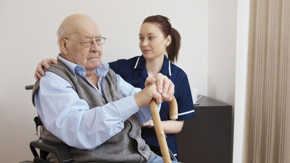 young nurse hugging senior man in wheelchair. Unhappy elderly man. Aged care. Generic, Thinkstock