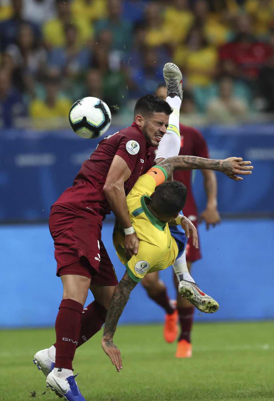 Brazil's Dani Alves, right, fights for the ball with Venezuela's Junior Moreno during a Copa America Group A soccer match at the Arena Fonte Nova in Salvador, Brazil, Tuesday, June 18, 2019. (AP Photo/Ricardo Mazalan)