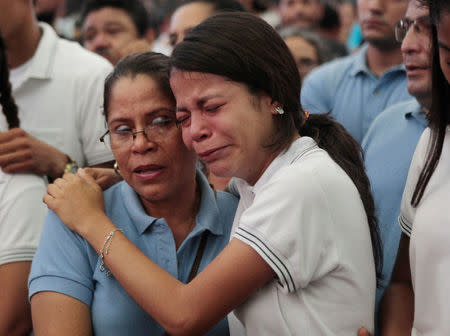 Students cry next to the casket of student Alvaro Conrado, 15, during a mass at the Santo Domingo church in Managua, Nicaragua April 21, 2018. According to the nation's Red Cross, Conrado was shot dead during a protest over a controversial reform to the pension plans of the Nicaraguan Social Security Institute (INSS). REUTERS/Oswaldo Rivas