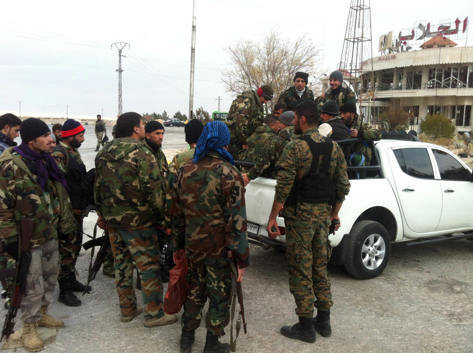 A picture taken on December 3, 2013 shows pro regime forces gathering around a vehicle near al-Nabak, in the Qalamoun region on the outskirts of the capital Damascus, where they battle with rebel fighters. (SAM SKAINE/AFP/Getty Images)