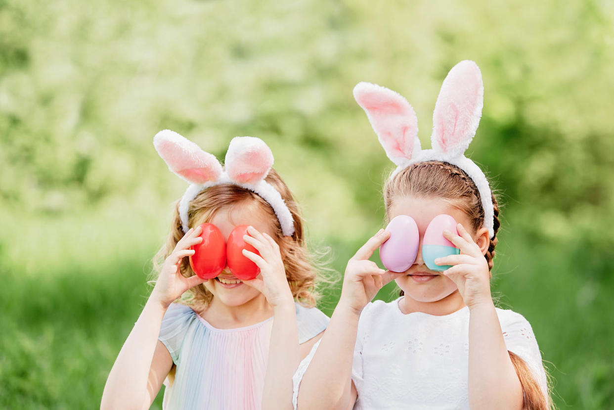 Group Of Children Wearing Bunny Ears Running To Pick Up colorful Egg On Easter Egg Hunt In Garden. (Serenko Nata / Getty Images/iStockphoto)