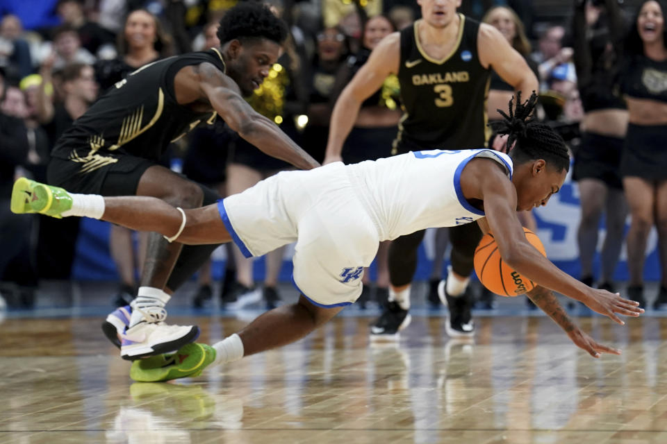 Kentucky's Rob Dillingham, right, dives for the ball next to Oakland's Rocket Watts, left, during the first half of a college basketball game in the first round of the men's NCAA Tournament, Thursday, March 21, 2024, in Pittsburgh. (AP Photo/Matt Freed)