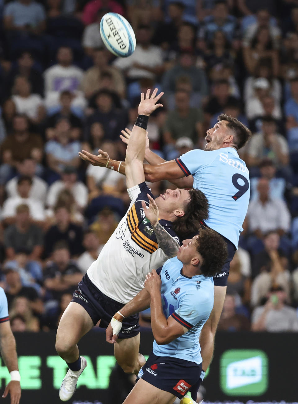 Jake Gordon, right, from the New South Wales Waratahs jumps for the ball with Corey Toole, left, from the ACT Brumbies during their Super Rugby Pacific Round 1 match at Allianz Stadium in Sydney, Australia Friday, Feb. 24, 2023. (David Gray/AAP Image via AP)