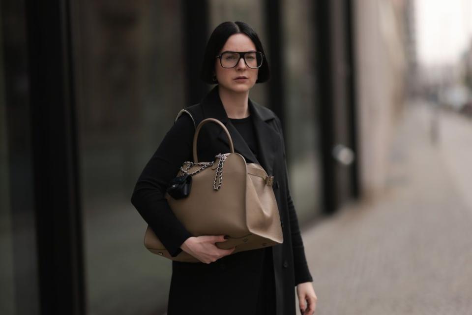 a woman carrying a leather work tote