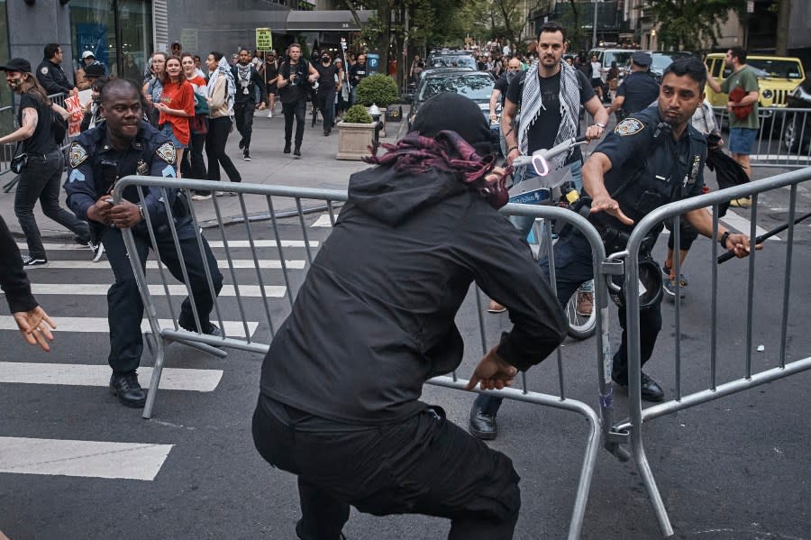 Palestinian protesters remove police barricades during the Met Gala at the Metropolitan Museum of Art where the Met Gala takes place on Monday, May 6, 2024, in New York. (AP Photo/Andres Kudacki)