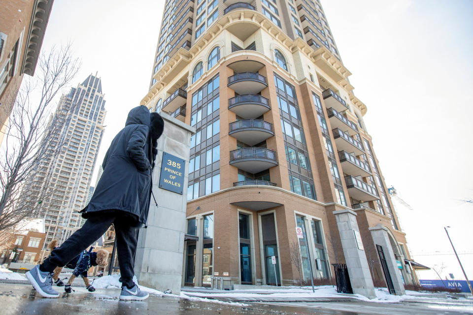 A woman walks her dog outside of a condominium building where Peel Region public health workers are to test all residents, after five cases of the South African coronavirus variant were confirmed, in Mississauga, Ontario, Canada February 15, 2021.  REUTERS/Carlos Osorio