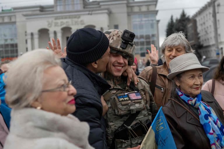 En esta foto de archivo tomada el 13 de noviembre de 2022, un hombre abraza a un soldado ucraniano mientras los residentes locales se reúnen para celebrar la liberación de Kherson