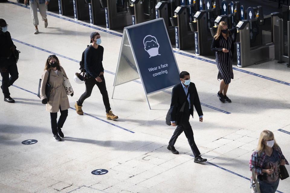 Passengers wearing face masks at Waterloo station as face coverings become mandatory to wear on public transport in the country, with the easing of further lockdown restrictions introduced to combat the spread of coronavirus, in London, Monday June 15, 2020. (Victoria Jones/PA via AP)