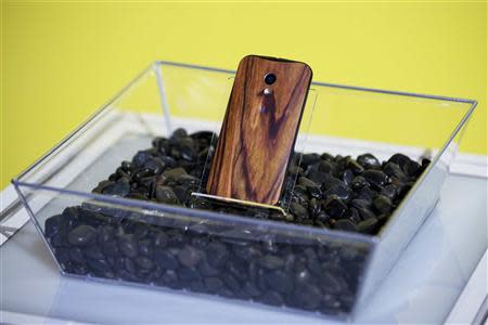 A phone with a wooden back on it rests in a display at a launch event for Motorola's new Moto X phone in New York, in this August 1, 2013, file photo. REUTERS/Lucas Jackson/Files