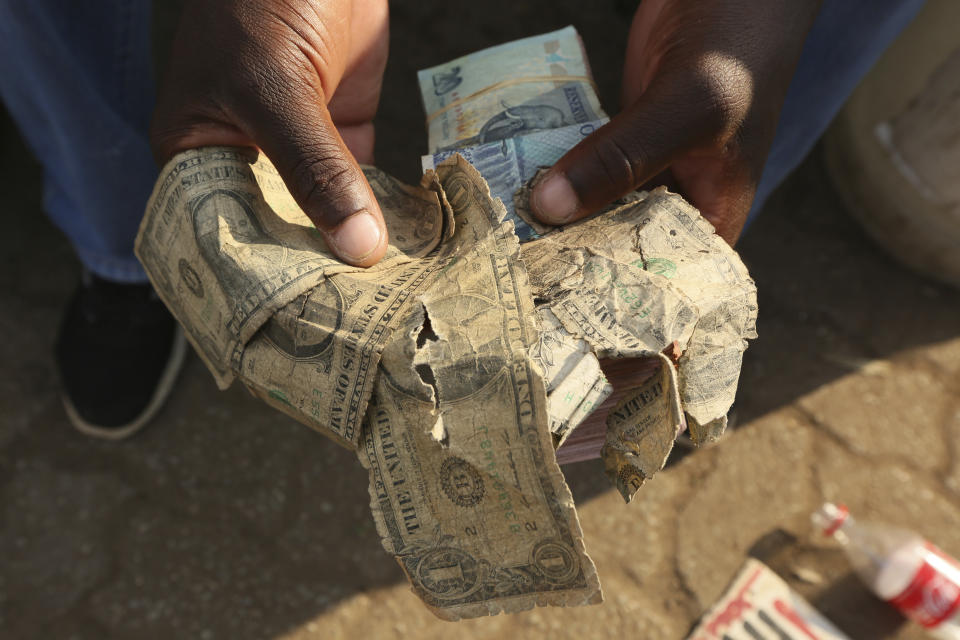 File - Tattered $1 U.S. bills are shown at a market in Harare, Zimbabwe, on Oct, 21, 2020. Enterprising traders there repaired the old notes for customers. Across the developing world, many countries are fed up with America's dominance of the global financial system — and especially the power of the dollar. ( AP Photo/Tsvangirayi Mukwazhi, File)