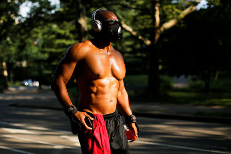 A man walks with a mask on a hot summer day in Central Park, Manhattan, New York, U.S., July 1, 2018. REUTERS/Eduardo Munoz