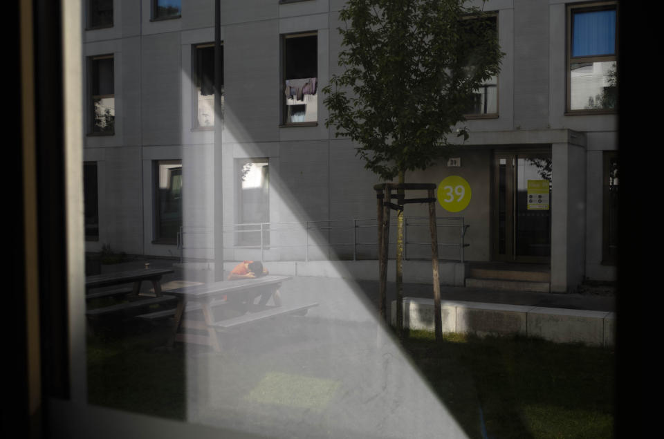 A young man rests in front of a shelter for temporary accommodation for new asylum seekers near the central registration in Berlin, Germany, Monday, Sept. 25, 2023. Across Germany, officials are sounding the alarm that they are no longer in a position to accommodate migrants who are applying for asylum. (AP Photo/Markus Schreiber)