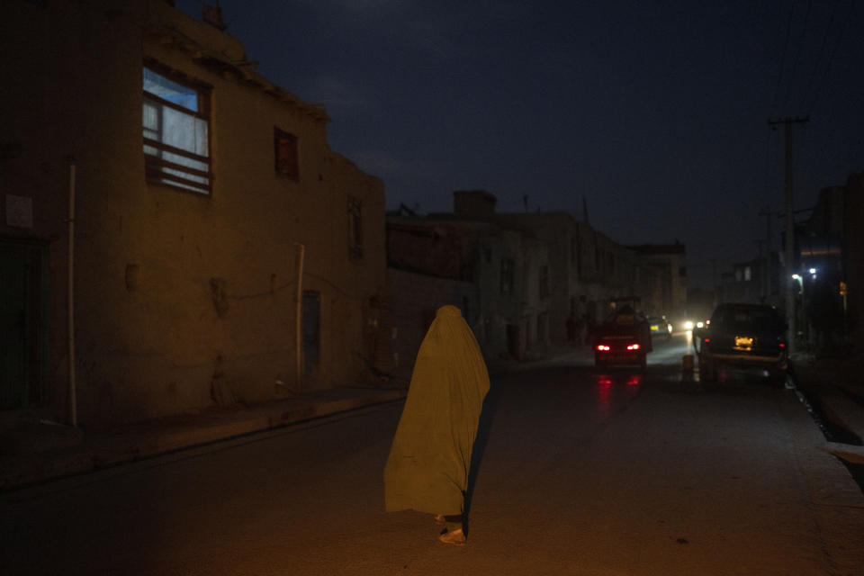 A woman wearing a burka walks down a street in Kabul, Afghanistan, Tuesday, Nov. 16, 2021. (AP Photo/Petros Giannakouris)