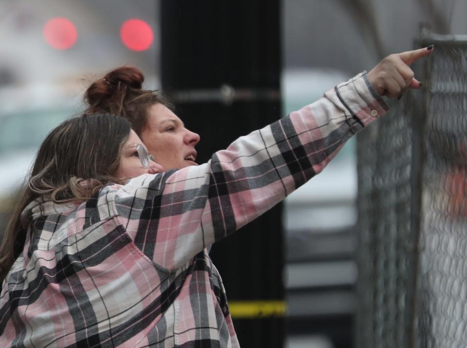 Erin Snider points as she and her sister Brooke Longheier, owner of CJ Duncan Jewelers, watch the demolition of the buildings at 14 Lincoln Way E and 20 Lincoln Way E in downtown Massillon that are next to the jewelry shop on Sunday.