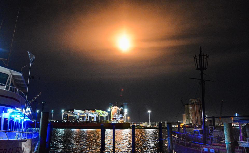 With the blue lights of the charter boat Canaveral Princess glowing on the left, and a freighter unloading at the cargo dock, a SpaceX Falcon 9 rocket lights up the sky Monday night over Port Canaveral.