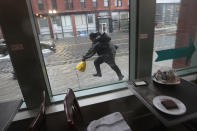 <p>A man dashes through rising waters on a flooded Causeway Street in Boston, as seen through a coffee shop window, during a nor’easter storm on March 2, 2018. (Photo: Suzanne Kreiter/The Boston Globe via Getty Images) </p>