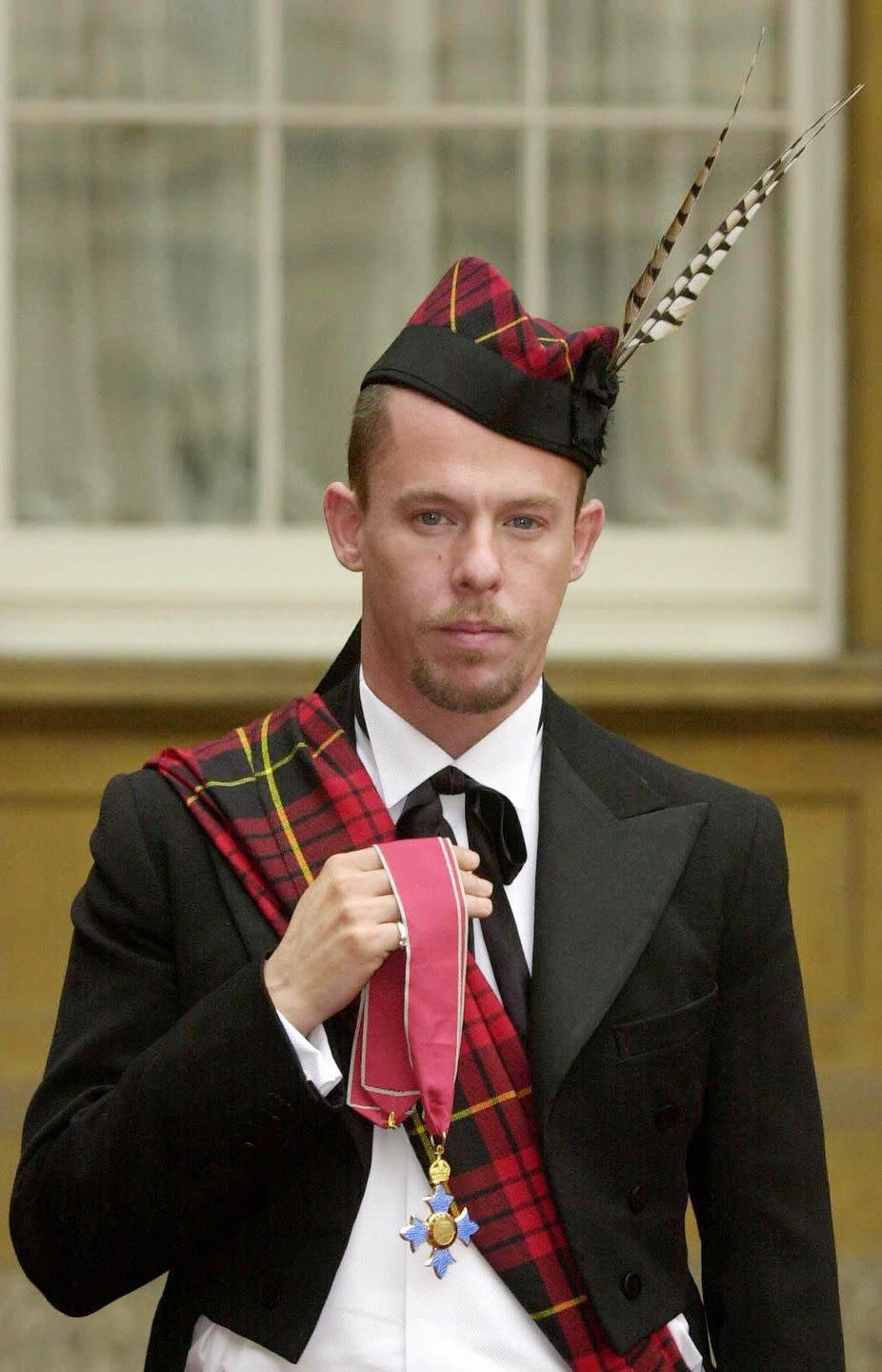 <p>British fashion designer Alexander McQueen chose to honor his heritage and sported a tartan sash and matching hat when he was awarded an OBE by Queen Elizabeth.</p>