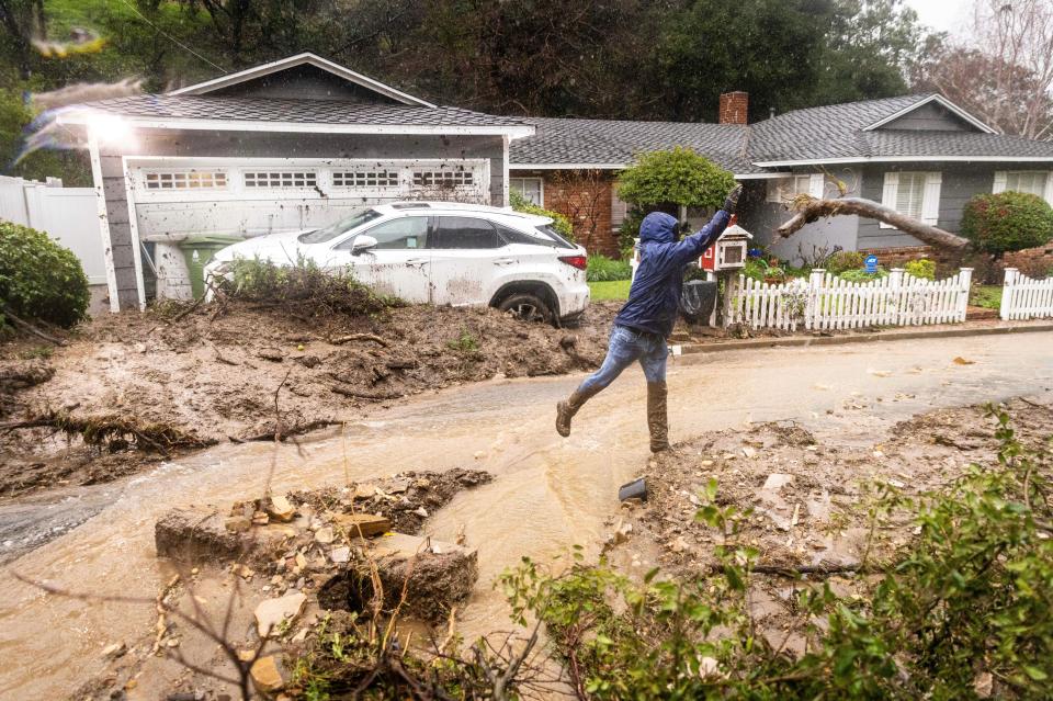 A man clears debris from a mudslide during rainstorm on Monday in Los Angeles. (AP)