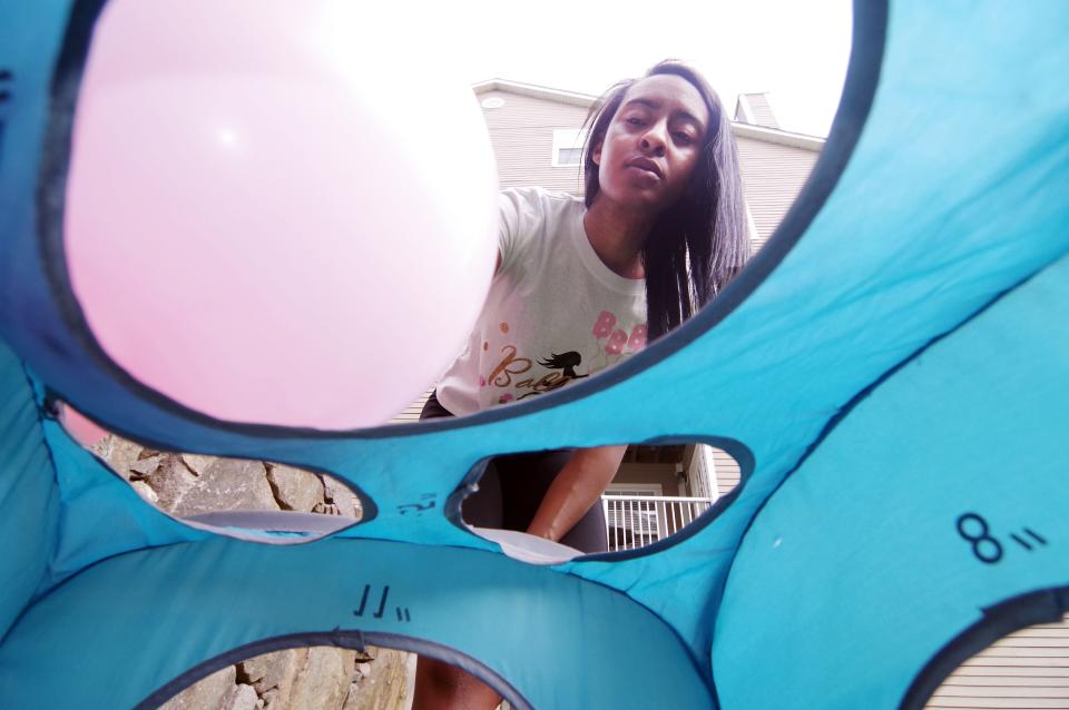 After blowing up the balloon, Briuna Shoulders of Quincy, originally from Brockton, looks to find the right fitting to match other balloons she has applied to the product for her customer on Thursday, May 5, 2022.
