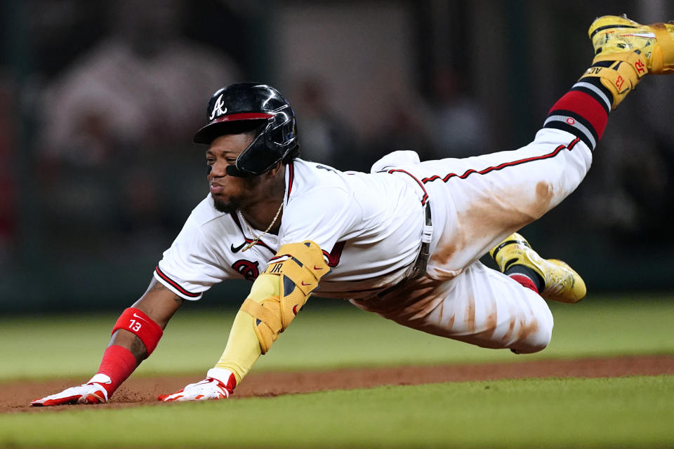Atlanta Braves' Ronald Acuna Jr. slides into second base with an RBI double during the fourth inning of the team's baseball game against the New York Mets on Monday, Aug. 15, 2022, in Atlanta. (AP Photo/John Bazemore)