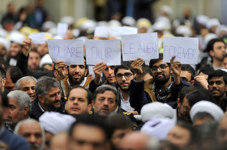 People hold signs as Iran's Supreme Leader Ayatollah Ali Khamenei speaks, Iran, January 9, 2018. Leader.ir/Handout via REUTERS