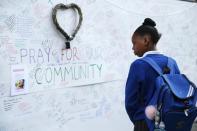 <p>A schoolgirl looks at messages of support for those affected by the massive fire in Grenfell Tower, in London, Thursday, June 15, 2017. (Photo: Alastair Grant/AP) </p>