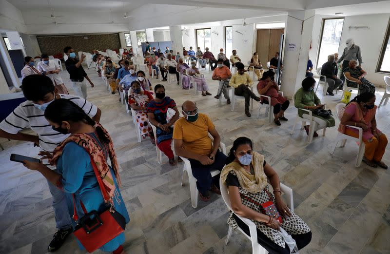 People sit in a waiting area to receive a dose of COVISHIELD, a coronavirus disease (COVID-19) vaccine, in Ahmedabad