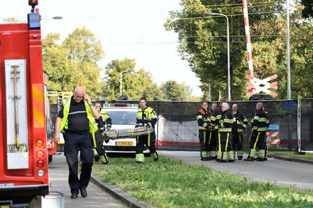 Rescue personnel work at the scene where a train struck a "cargo bicycle", popular with Dutch parents for transporting their children, at the city of Oss, Netherlands, September 20, 2018. REUTERS/Piroschka van de Wouw